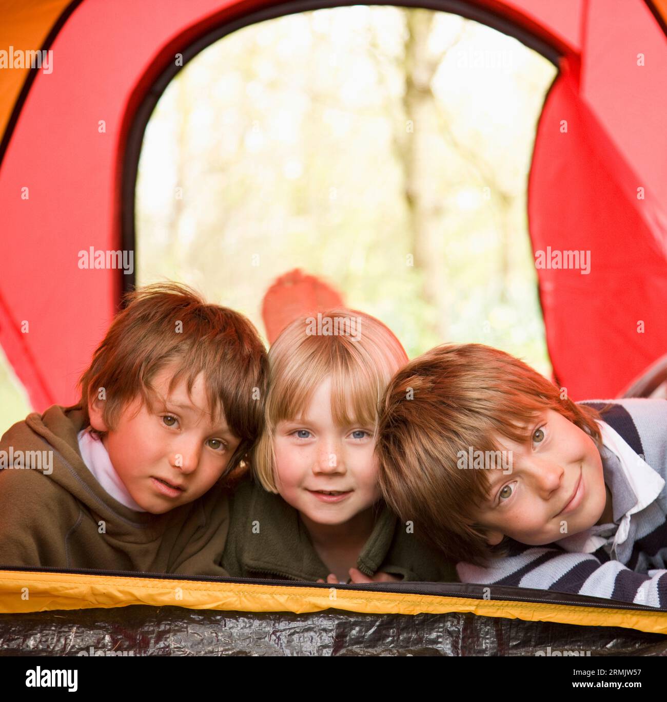 Ritratto di tre bambini giacente in una tenda Foto Stock