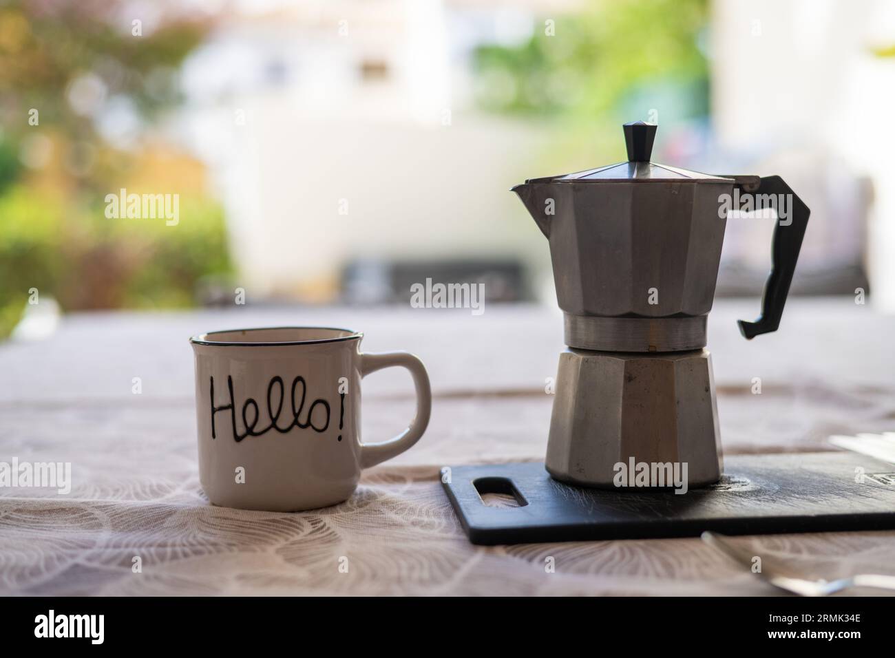 Tazza da caffè con messaggio "Hello" e macchina da caffè vintage. Foto Stock