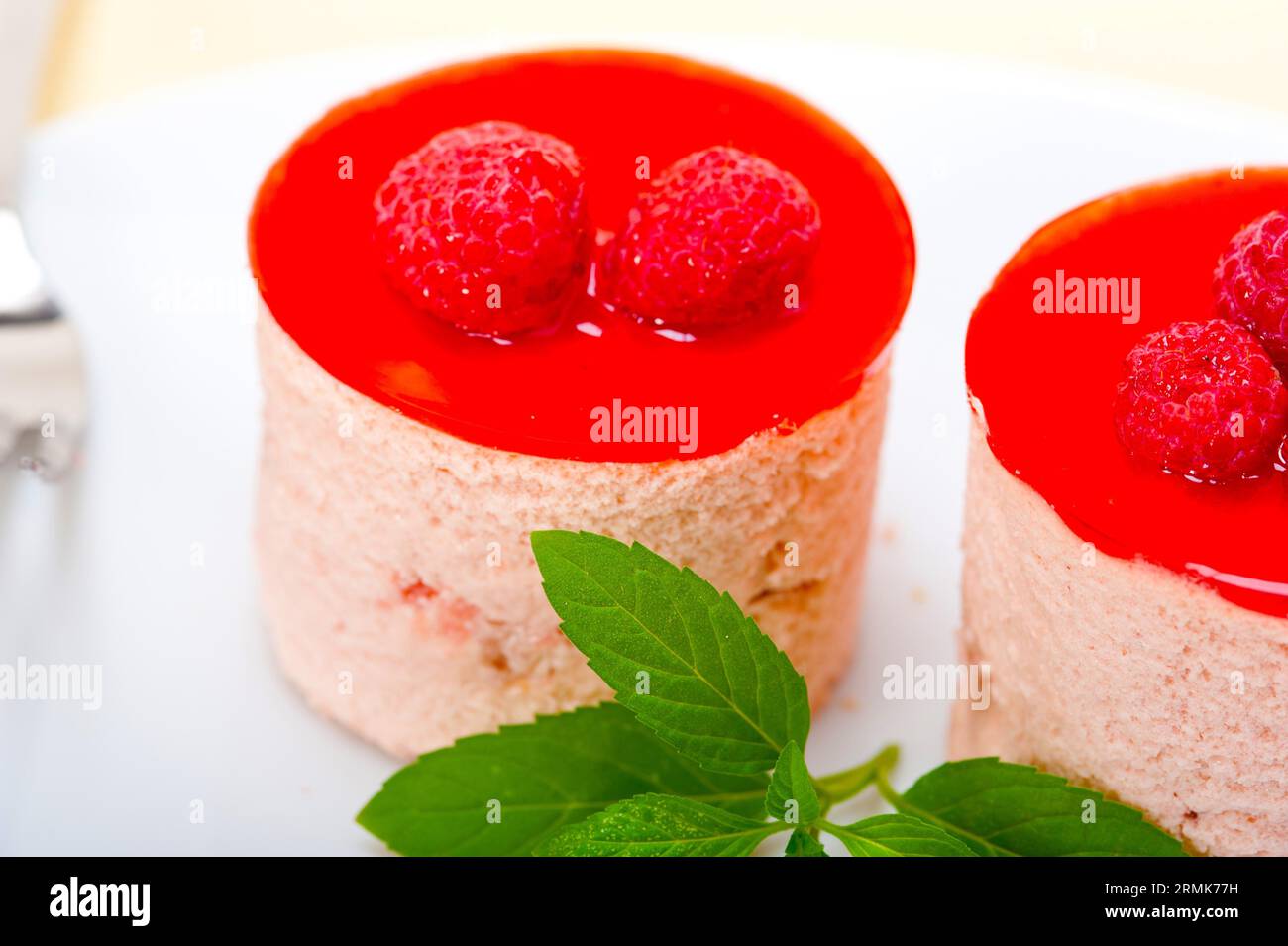 Dolce di mousse di lampone fresco a forma rotonda con foglie di menta Foto Stock