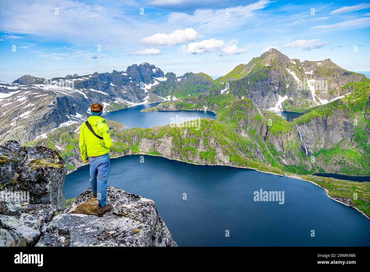 Alpinisti in cima al Munken, paesaggio montano con ripide vette rocciose e laghi Tennesvatnet e Krokvatnet, nella cima posteriore del Foto Stock