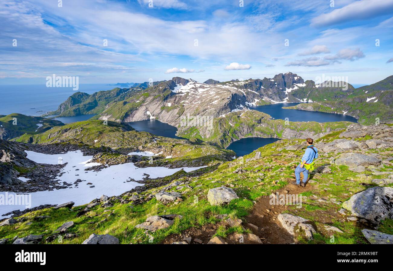 Alpinisti che scalano il Munken, paesaggio montano con ripide vette rocciose e il lago Tennesvatnet, Krokvatnet e Fjerddalsvatnet, Moskenesoya, Lofoten Foto Stock