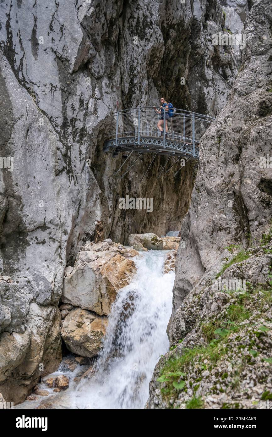 Escursionista su un ponte, Hammersbach scorre attraverso Hoellentalklamm, vicino a Garmisch-Partenkirchen, Werdenfelser Land, alta Baviera, Baviera, Germania Foto Stock