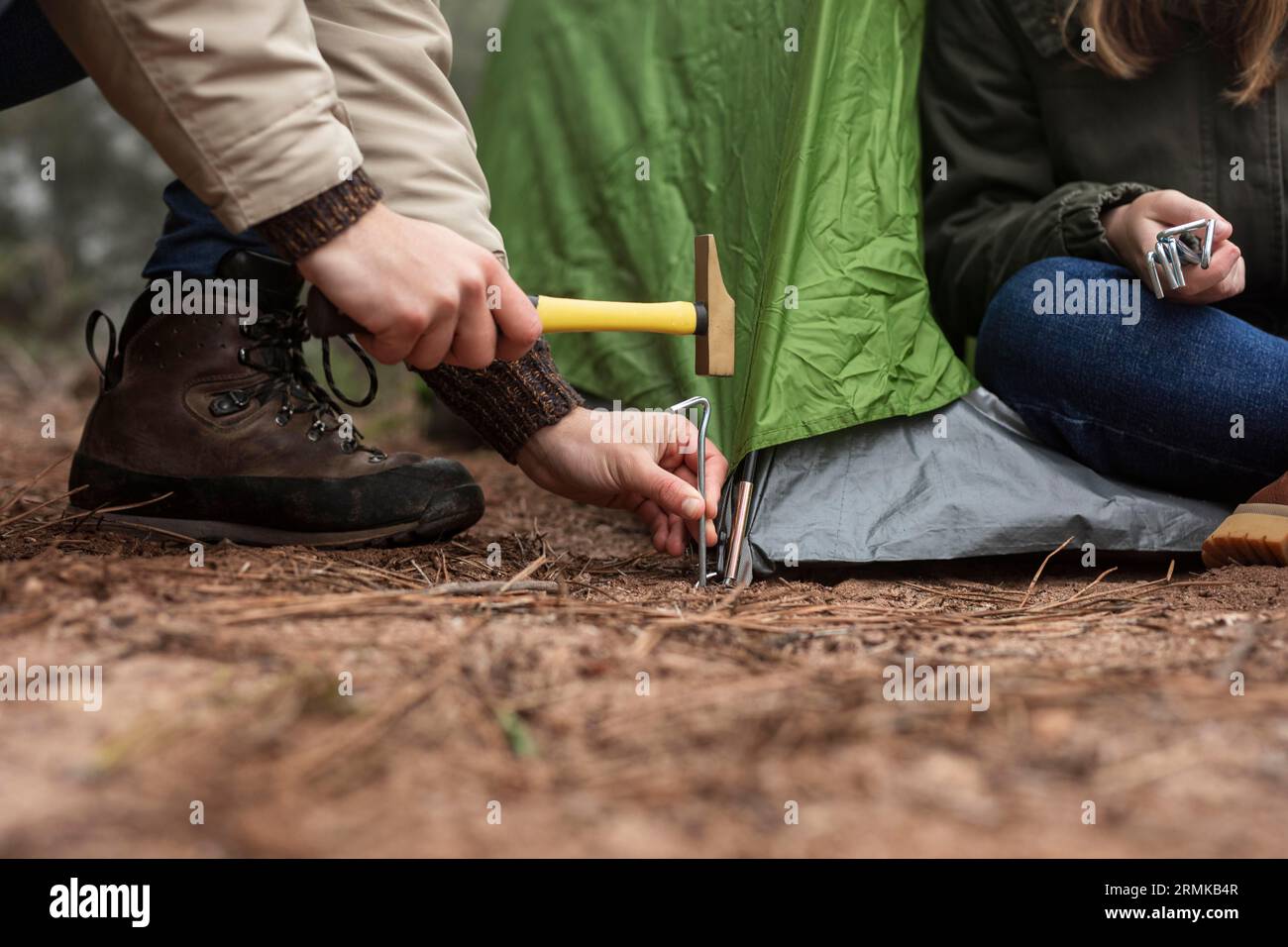 Chiudere la gente che mette una tenda verde Foto Stock