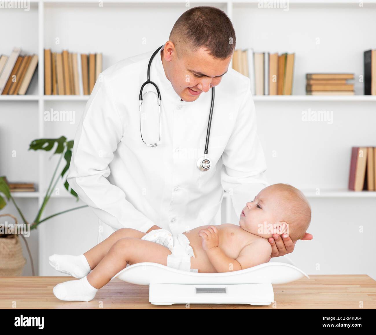 Un medico attento che tiene la testa del bambino Foto Stock