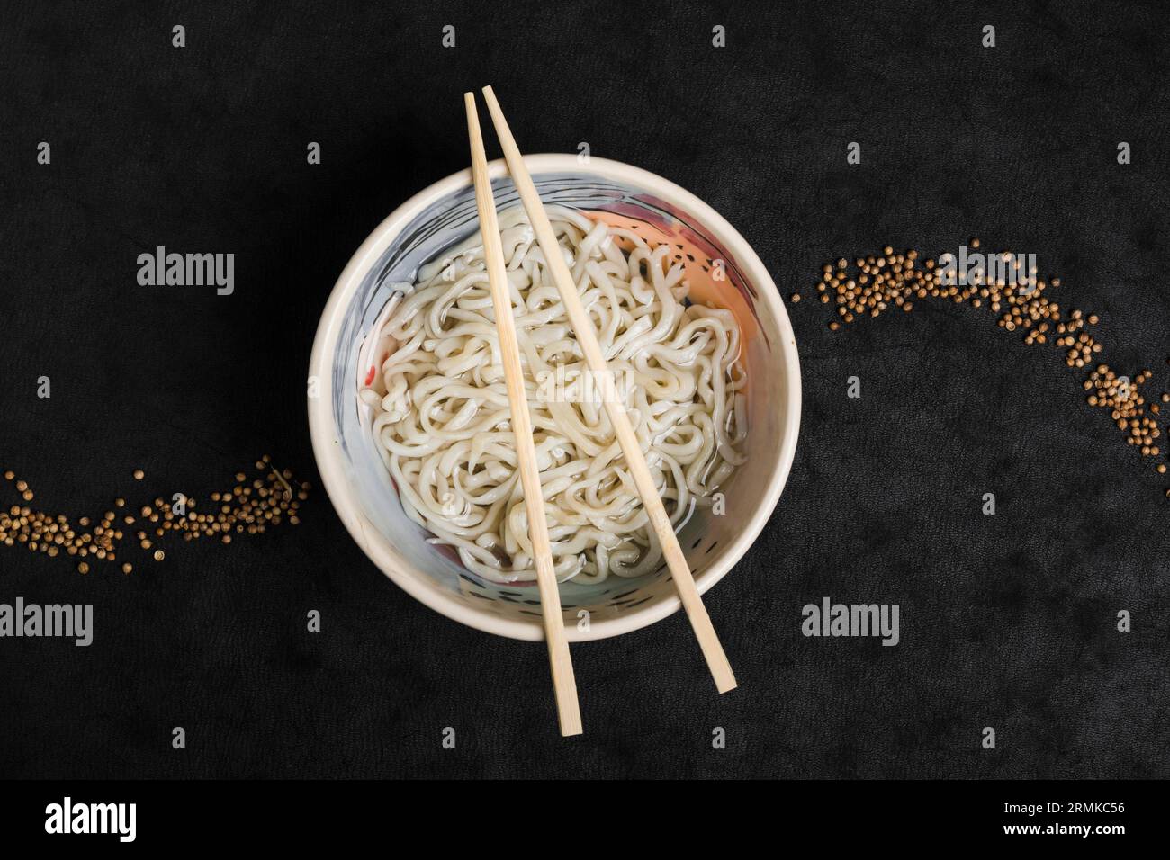 Tagliatelle udon fatte in casa, cibo giapponese con semi di coriandolo, sfondo nero Foto Stock