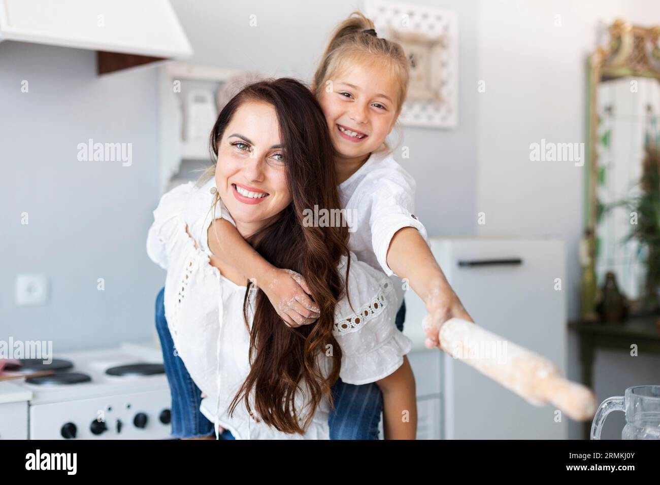 Felice madre figlia in posa con il rullo da cucina Foto Stock