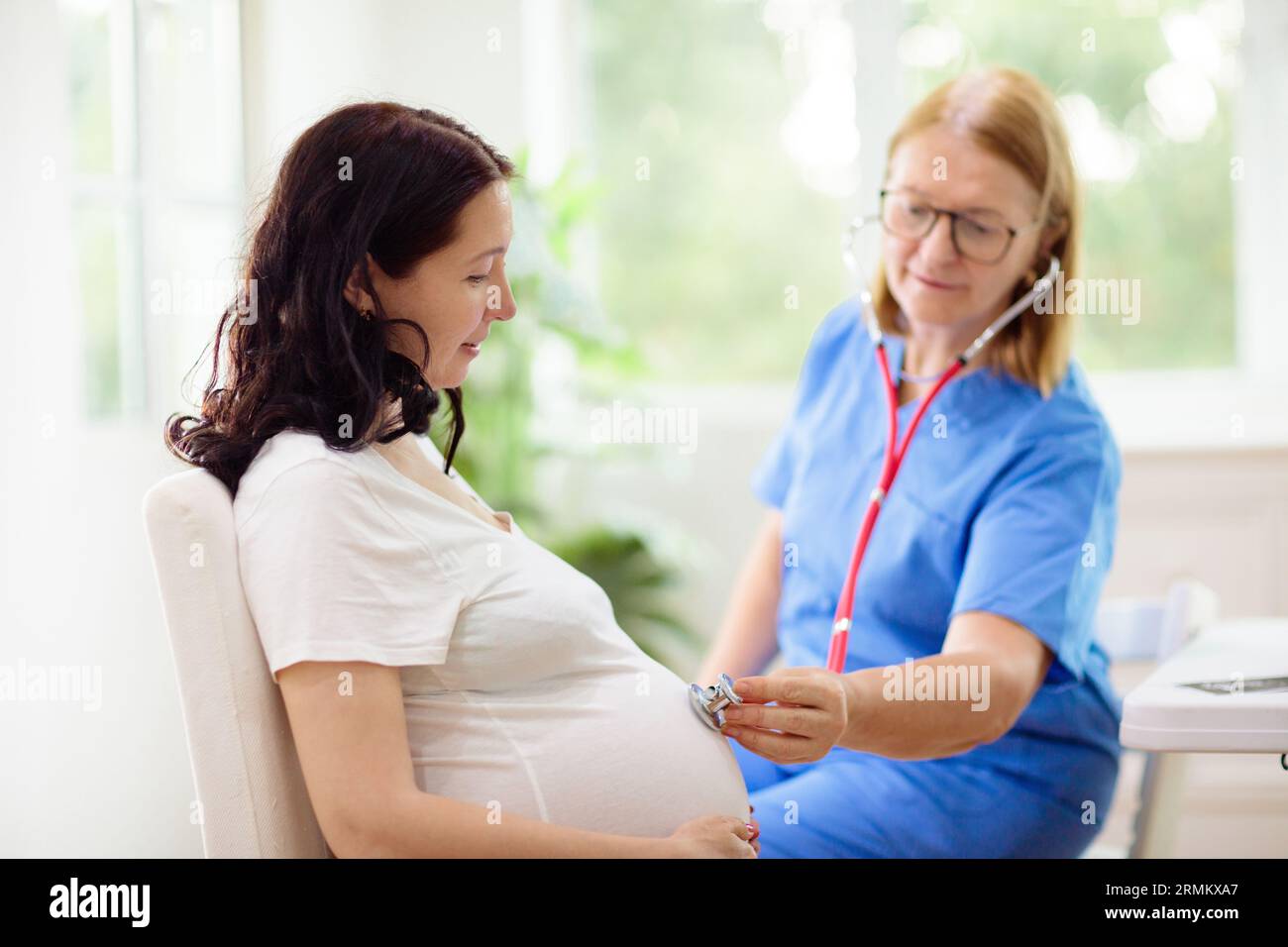 Medico che esamina la donna incinta. Controllo della gravidanza. Giovane donna asiatica presso l'ufficio ginecologo per esame prenatale. Ostetricia ginecologia che mostra il sonogramma del bambino del paziente. Foto Stock