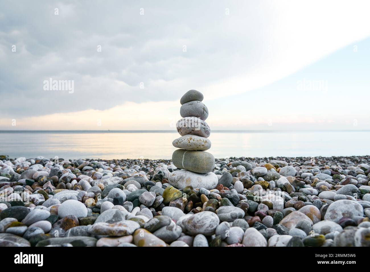 Torre in pietra sulla spiaggia. Cairn. Simbolo di equilibrio. Foto Stock