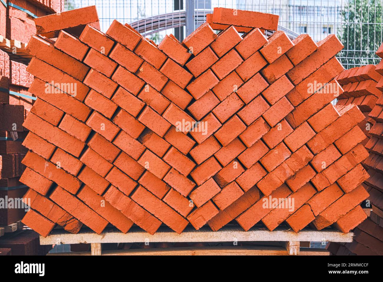 Primo piano di mattoni. Processo di costruzione di abitazioni e concetto di materiali da costruzione. Mattoni rossi per la posa in cantiere. Modello di carta da parati in mattoni Foto Stock
