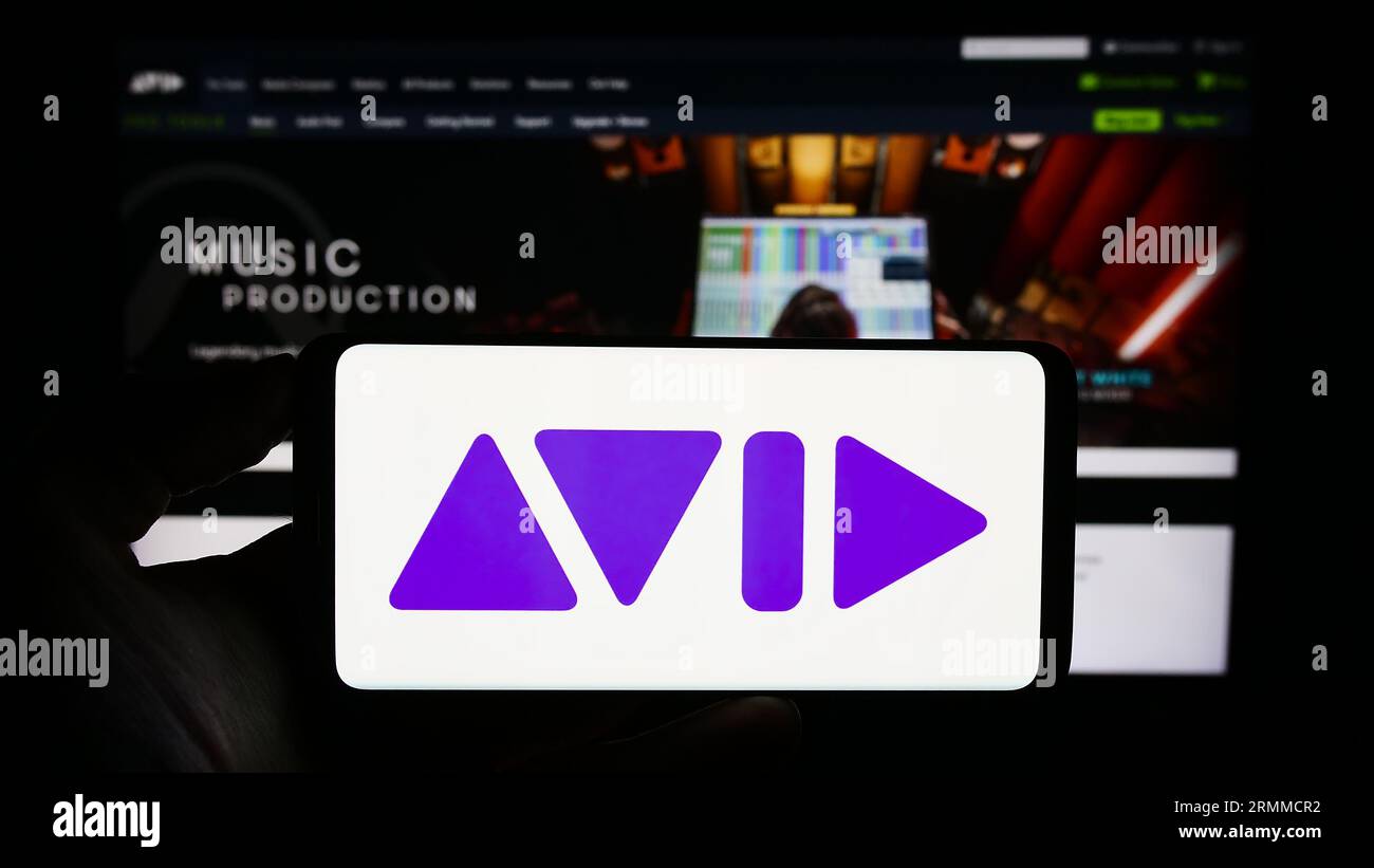 Persona che possiede il cellulare con il logo della società di software statunitense Avid Technology Inc. Sullo schermo davanti alla pagina Web aziendale. Concentrarsi sul display del telefono. Foto Stock