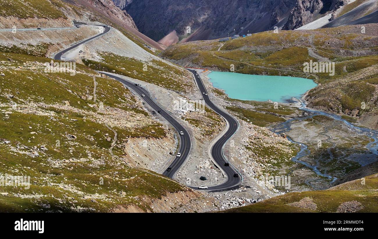 Urumqi. 23 agosto 2023. Questa foto aerea scattata il 23 agosto 2023 mostra la vista lungo la Duku Highway nella regione autonoma Xinjiang Uygur della Cina nordoccidentale. La Duku Highway, considerata una delle strade più belle della Cina, è una panoramica sezione montuosa che si estende per oltre 500 chilometri tra Dushanzi e Kuqa sulla China National Highway 217 nello Xinjiang. Un'importante strada che collega il nord e il sud dello Xinjiang, Duku Highway è famosa anche per il suo spettacolare paesaggio naturale che include ghiacciai, foreste e praterie. Crediti: Wang Peng/Xinhua/Alamy Live News Foto Stock