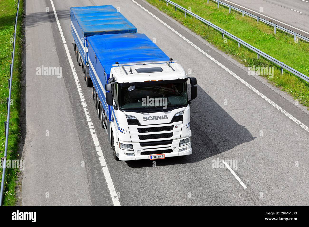 Il dumper bianco Scania R650 tira un rimorchio per cereali lungo l'autostrada in una giornata di inizio autunno con vista elevata. Salo, Finlandia. 24 agosto 2023. Foto Stock