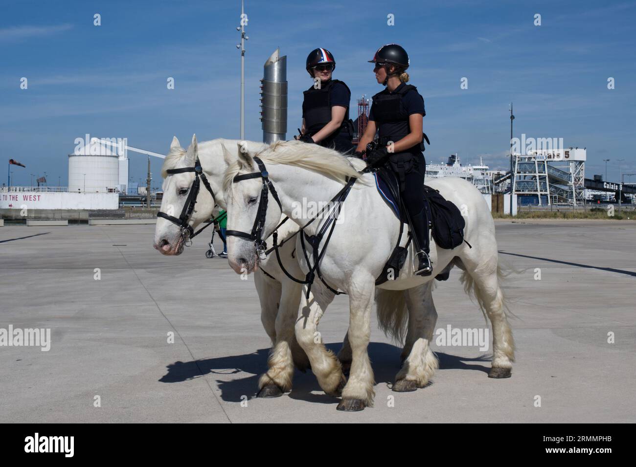 Due poliziotti a cavallo, che esercitano cavalli, lungomare di Calais, Francia Foto Stock