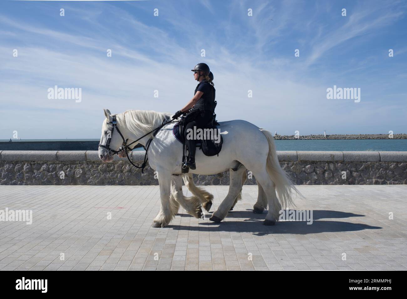 Due poliziotti a cavallo, che esercitano cavalli, lungomare di Calais, Francia Foto Stock