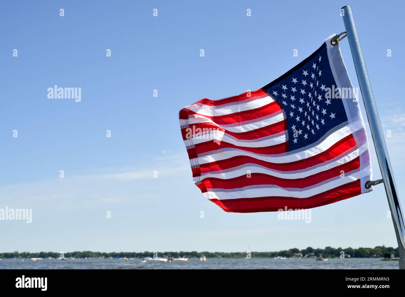 La bandiera americana che sventola nel vento sotto il cielo blu Foto Stock