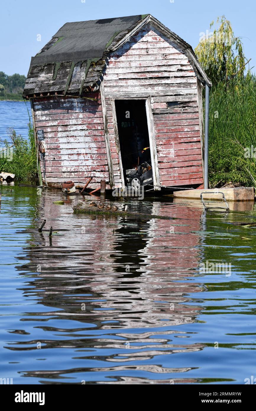 Un deposito di legno abbandonato e intemprato sull'acqua Foto Stock