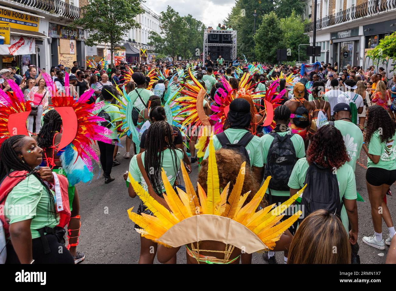 Pubblico e partecipanti in strada a seguito di un camion con impianto audio alla Notting Hill Carnival Grand Parade 2023, Londra, Regno Unito. Strada trafficata Foto Stock