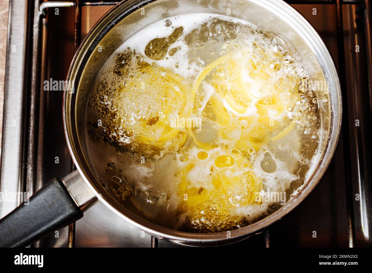 Le tagliatelle vengono cotte in una pentola sulla stufa. Foto Stock