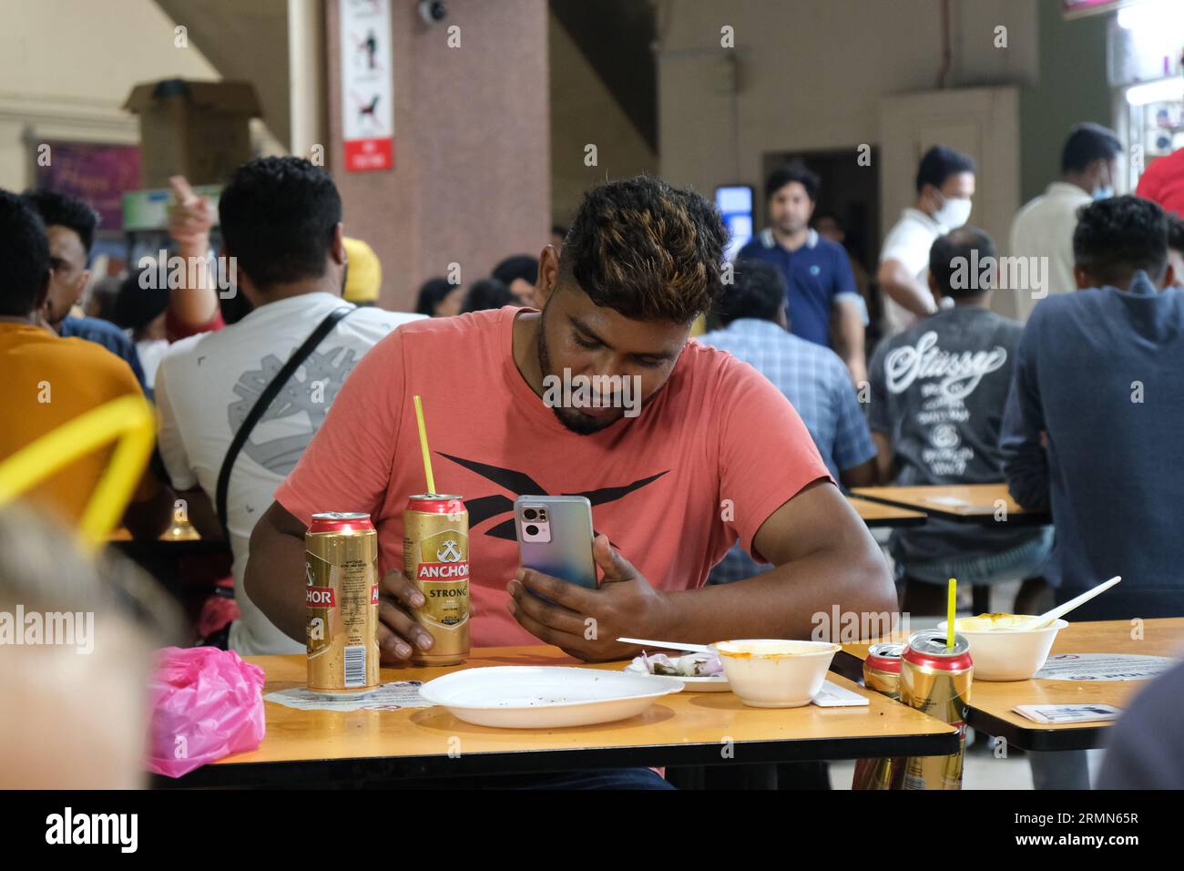 Un uomo beve birra al Tekka Center, un centro gastronomico incentrato sull'India meridionale nella vivace Little India di Singapore. 22/10/2022 Foto Stock
