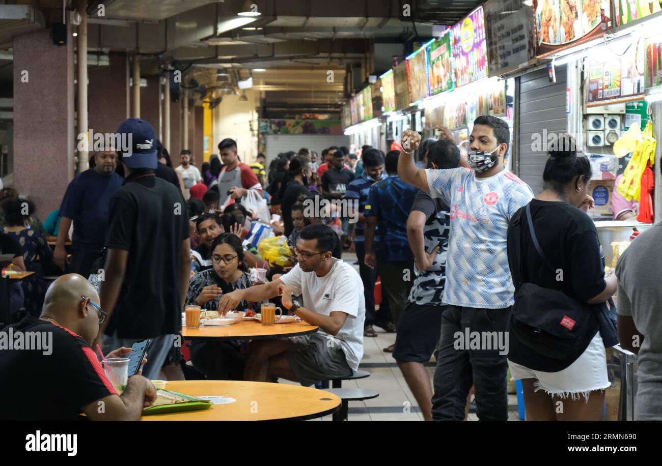 Hawker invita i potenziali clienti al Tekka Center, un vivace centro di ristorazione indiano nella Little India di Singapore. 22/10/2022 Foto Stock