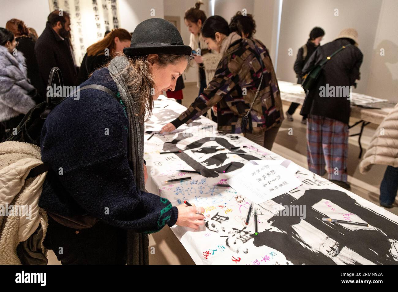 Donna che scrive calligrafia al Christie's Lates: Year of the Rabbit 2023, Londra, Inghilterra Foto Stock