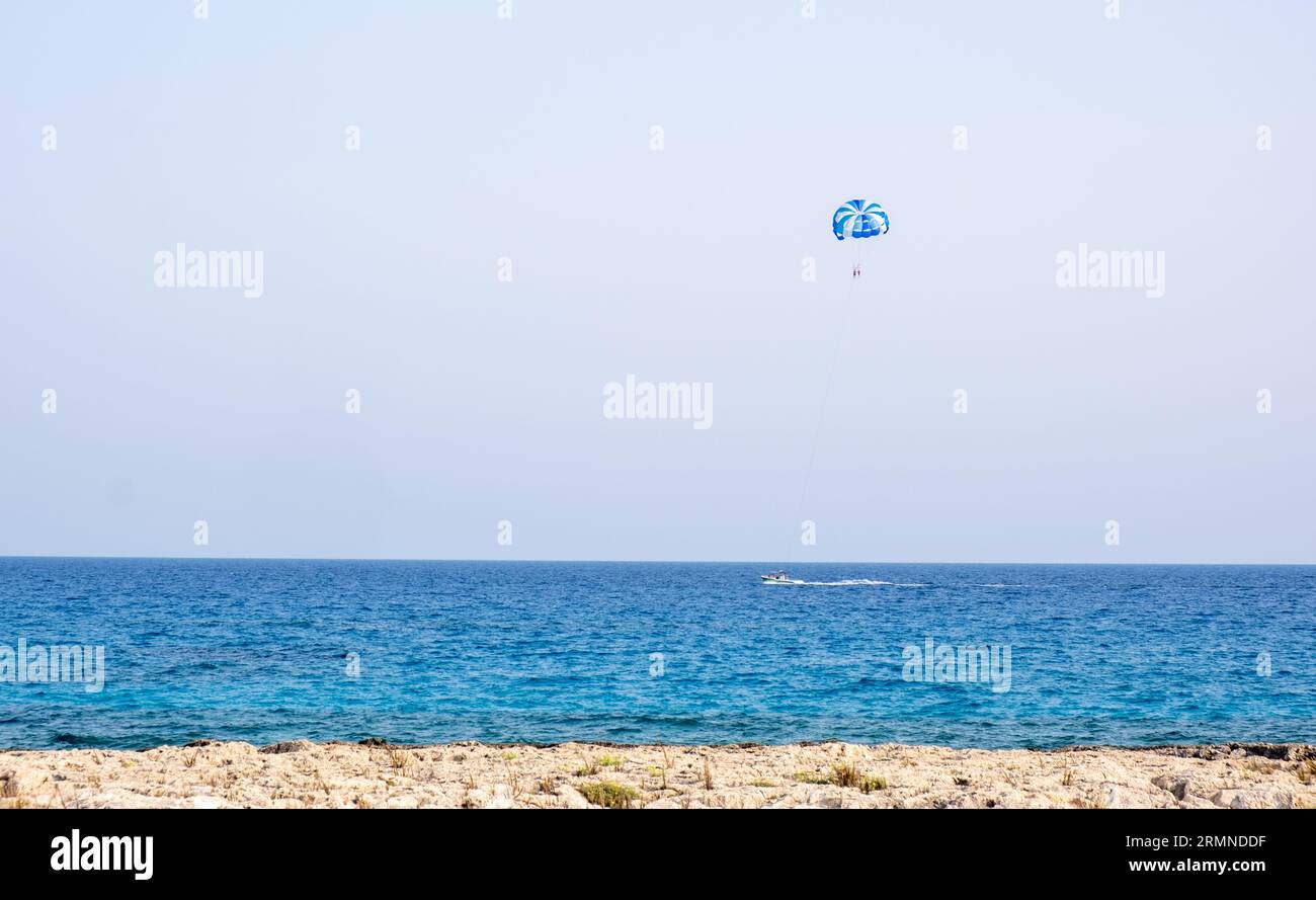 Turisti che fanno paracadutismo in mare. Vacanze estive di intrattenimento, sport estremi all'aperto Foto Stock