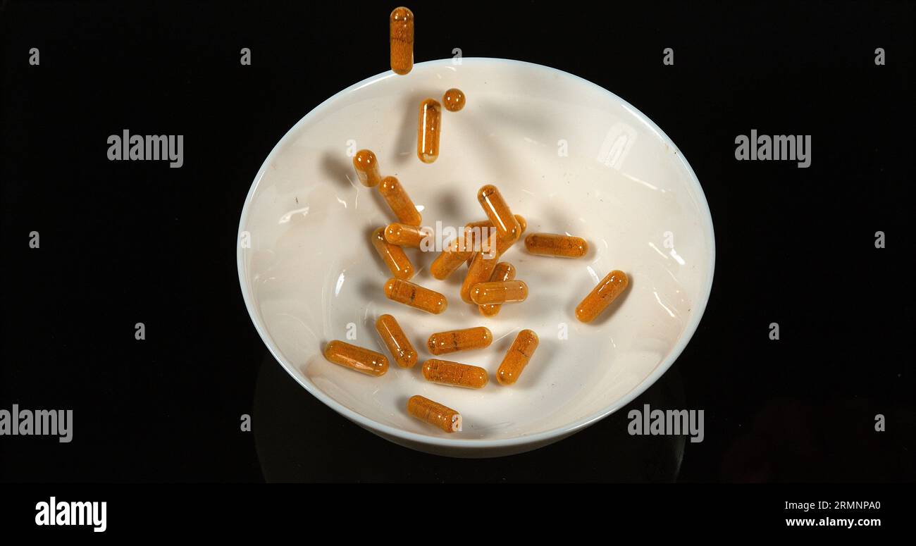 Curcuma, curcuma Longa, Capsule che cadono su sfondo nero, spezie indiane Foto Stock