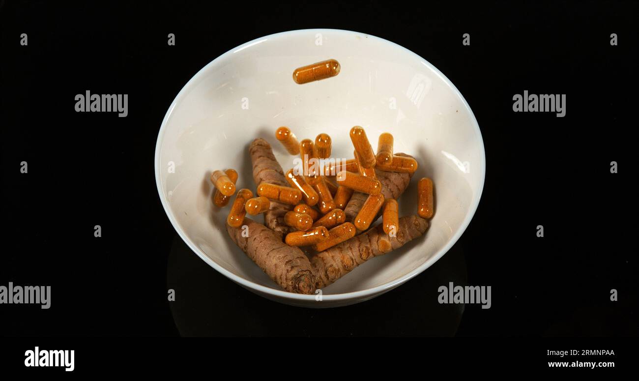 Curcuma, curcuma Longa, Capsule che cadono su sfondo nero, spezie indiane Foto Stock