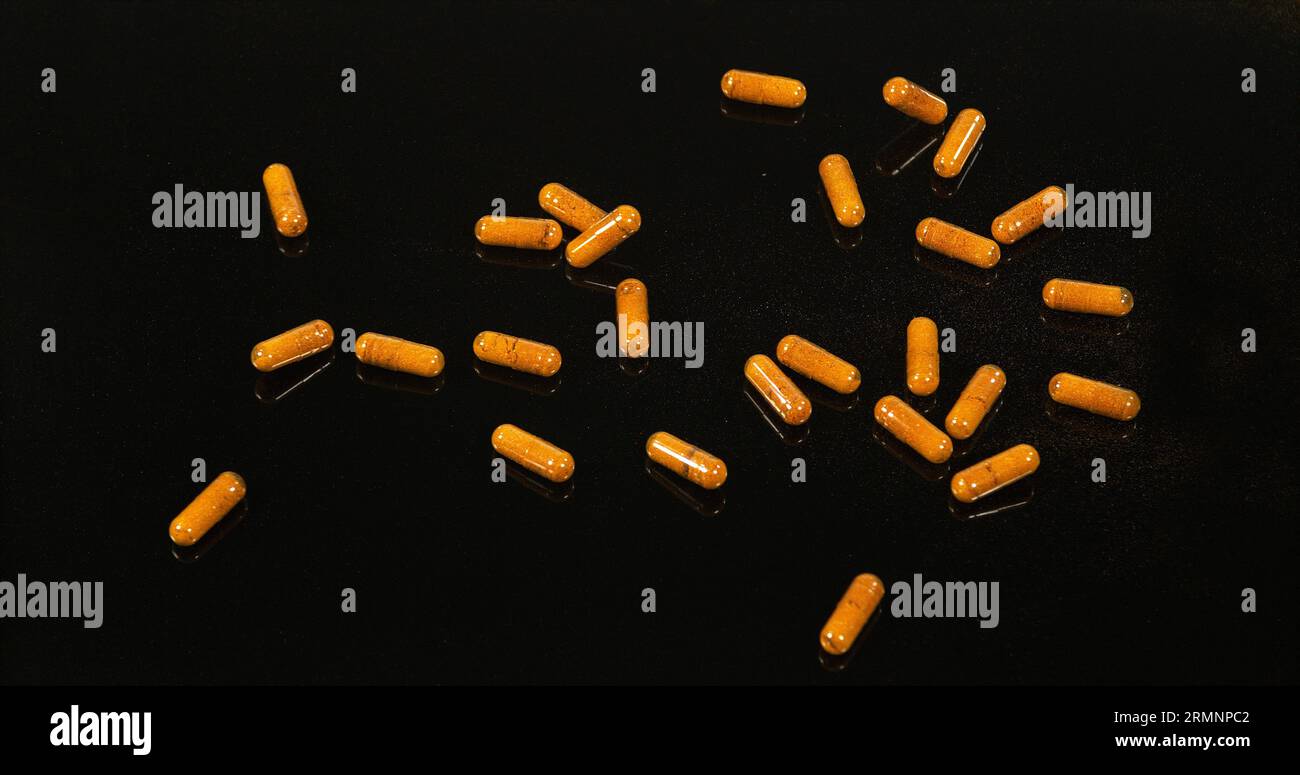 Curcuma, curcuma Longa, Capsule che cadono su sfondo nero, spezie indiane Foto Stock