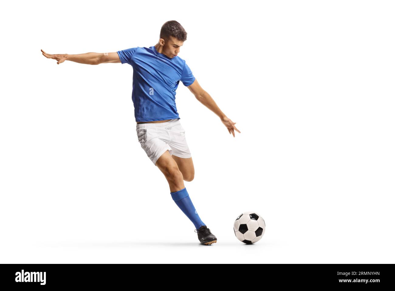 Giocatore di calcio con maglia blu che corre e si prepara a calciare una palla isolata su sfondo bianco Foto Stock