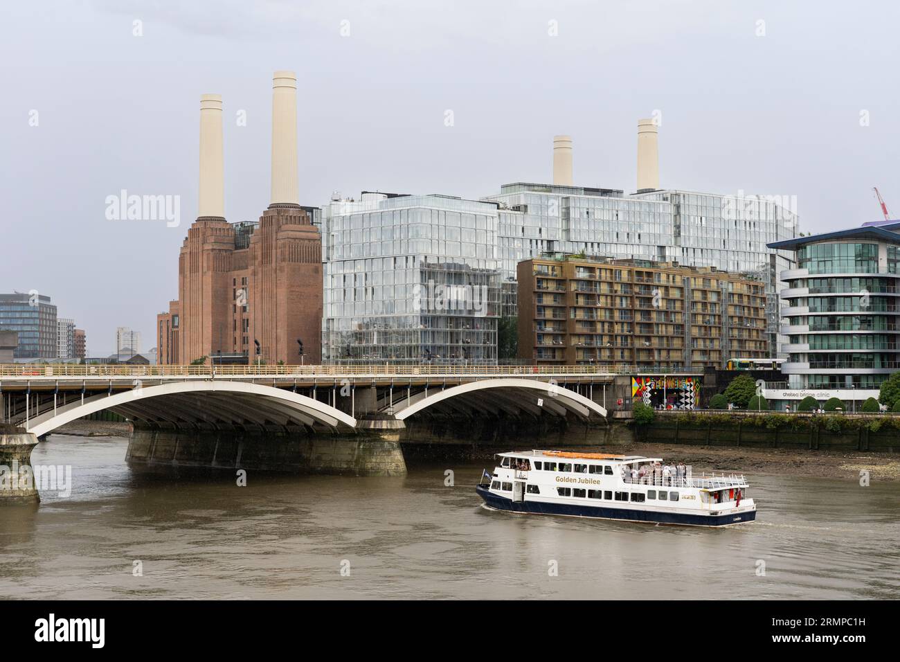 La festa in barca del Golden Jubilee passa sotto il ponte ferroviario di Grosvenor con alle spalle l'iconica riqualificazione della centrale elettrica di Battersea. Londra, Regno Unito Foto Stock