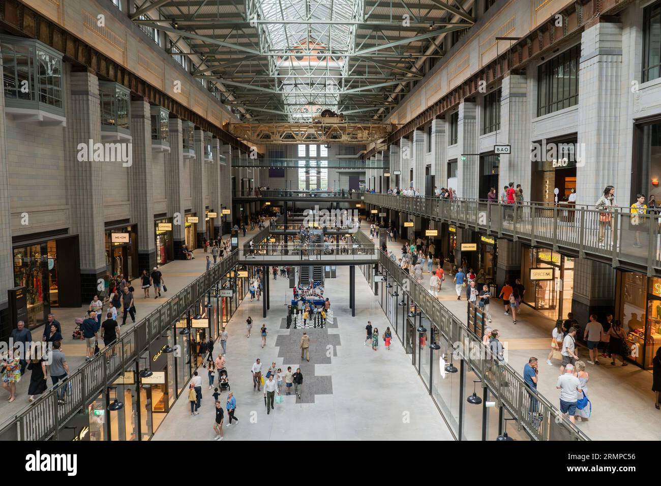 Turbine Hall A della centrale elettrica di Battersea, riqualificata e classificata come II*, con molti visitatori e acquirenti che riempiono il centro commerciale. Londra, Regno Unito Foto Stock