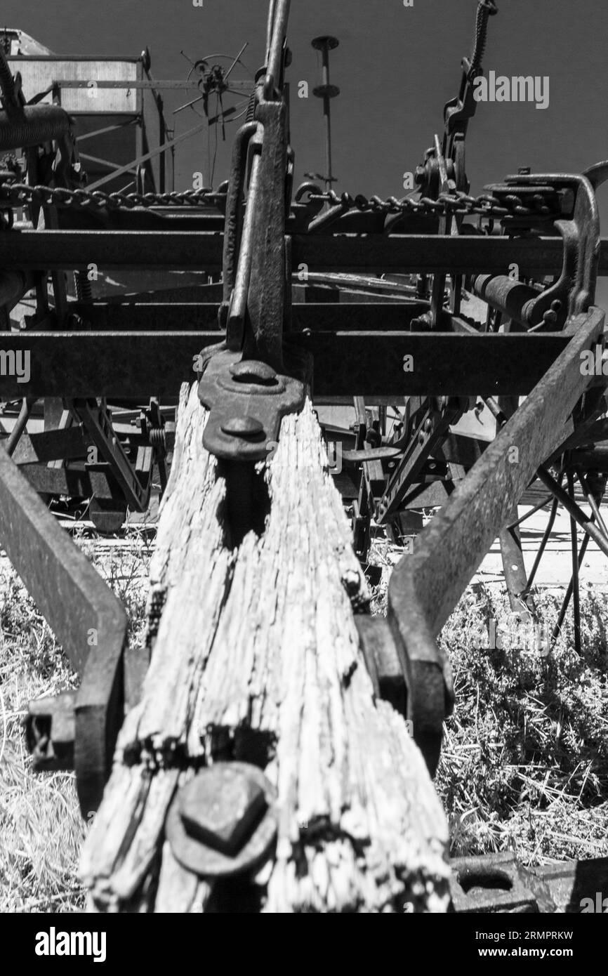 Una locomotiva d'epoca parcheggiata in una rustica stazione ferroviaria, circondata da macchinari antiquati Foto Stock