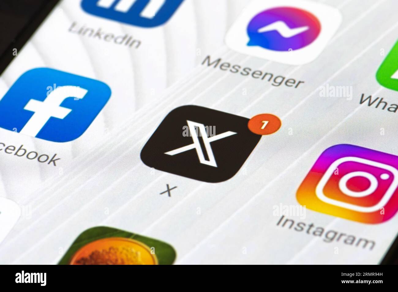 Logo iniziale di Twitter o X e app su uno smartphone. Social media online e servizio di social networking con notifica rossa e altre app Foto Stock