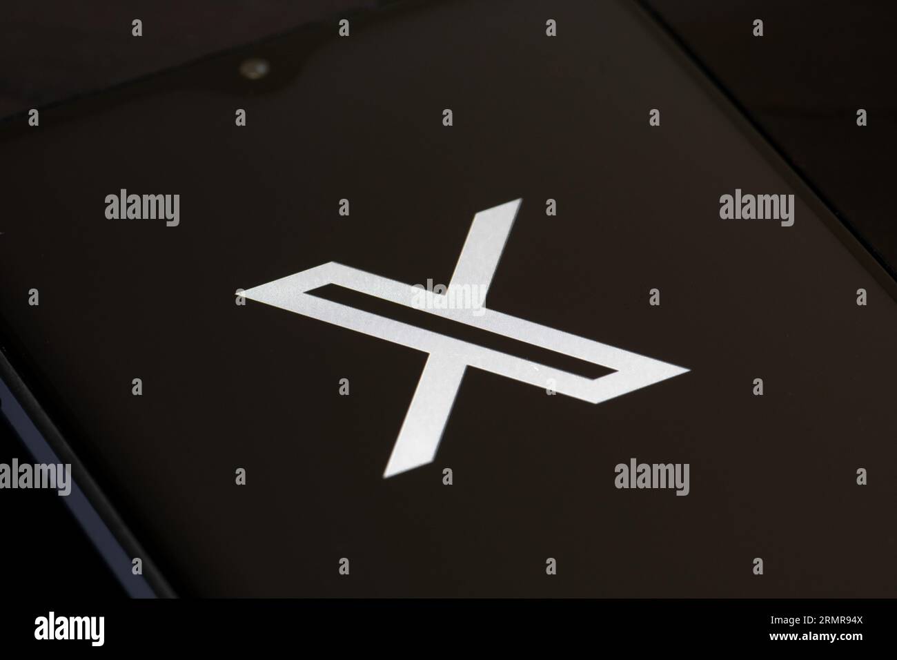 Logo iniziale di Twitter o X e app su uno smartphone su sfondo nero. Social media online e servizio di social network di proprietà di Elon Musk Foto Stock