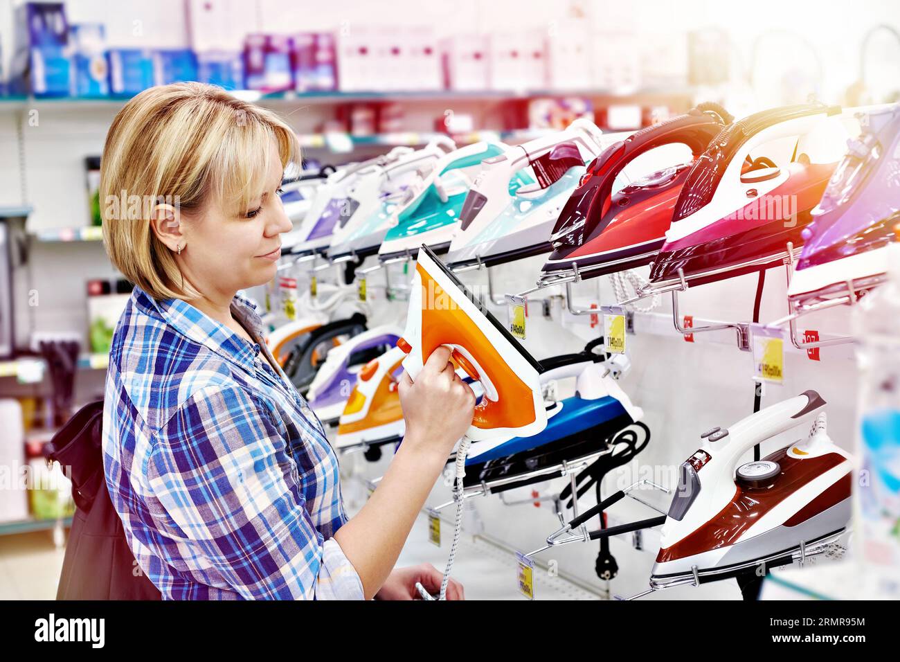 Donna casalinga che compra ferro in negozio Foto Stock