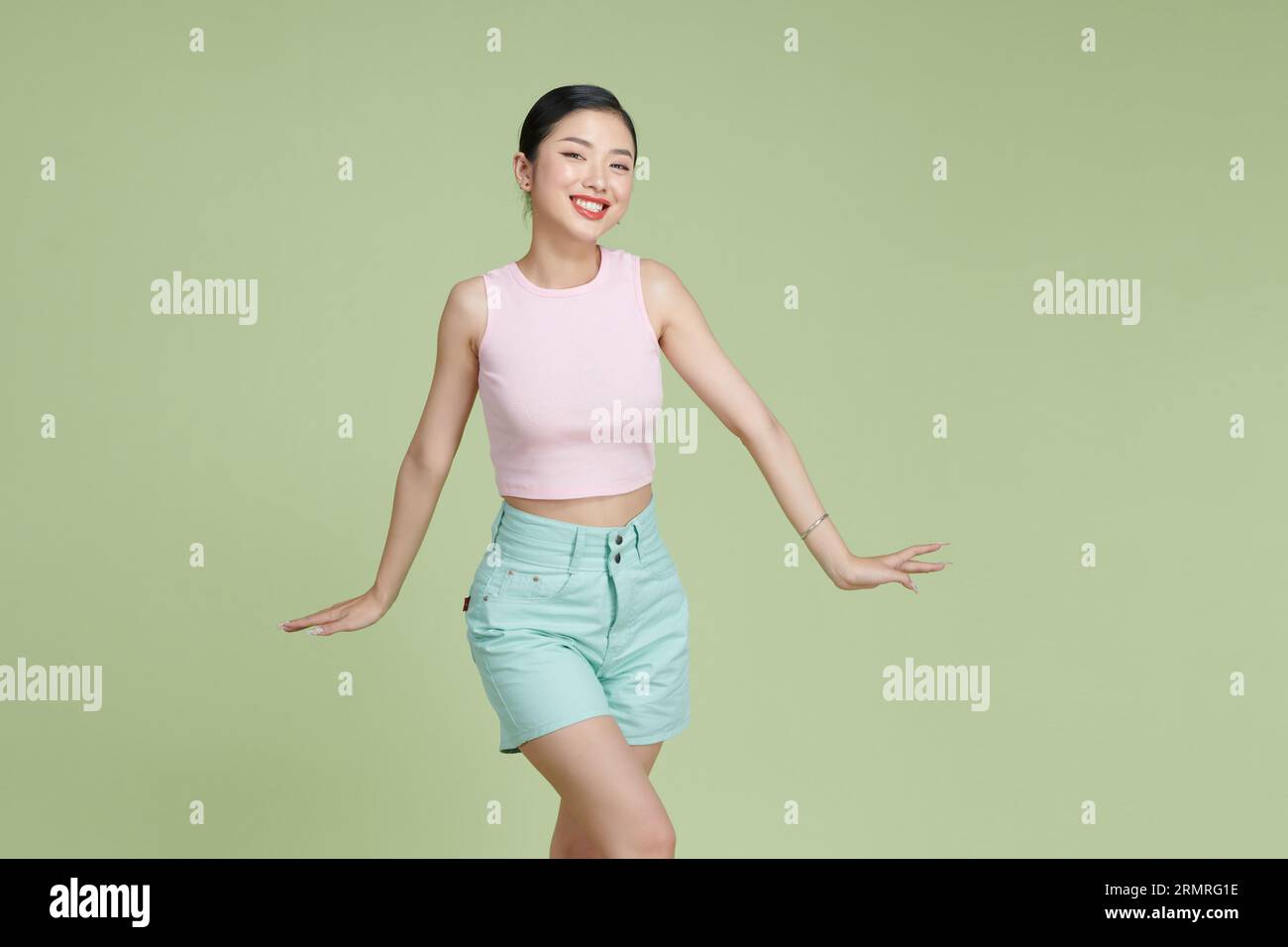 Giovane bella donna asiatica che si sente gioiosa e rilassante ballando e sorridendo Foto Stock