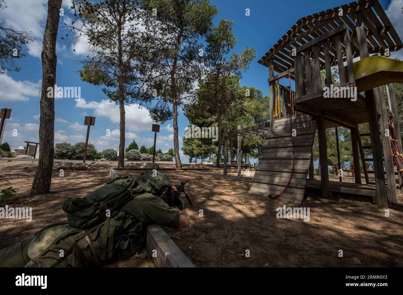 Un soldato israeliano punta la sua arma a durante un'operazione in un avamposto nel sud di Israele vicino al confine con Gaza, il 19 luglio 2014, il dodicesimo giorno dell'operazione bordo protettivo. Gli scioperi israeliani hanno ucciso 20 persone a Gaza sabato, prendendo il bilancio delle vittime da un bombardamento di 12 giorni a 318, mentre il capo delle Nazioni Unite Ban Ki-Moon si è diretto nella regione per unirsi agli sforzi di tregua. (Xinhua/li Rui)(zhf) ISRAEL-GAZA-BORDER-CONFLICT PUBLICATIONxNOTxINxCHN to Israeli Soldier mira la sua arma durante l'operazione ALL'avamposto nel sud di Israele vicino al confine con Gaza IL 19 luglio 2014, dodicesimo giorno dell'operazione Protective ed Foto Stock