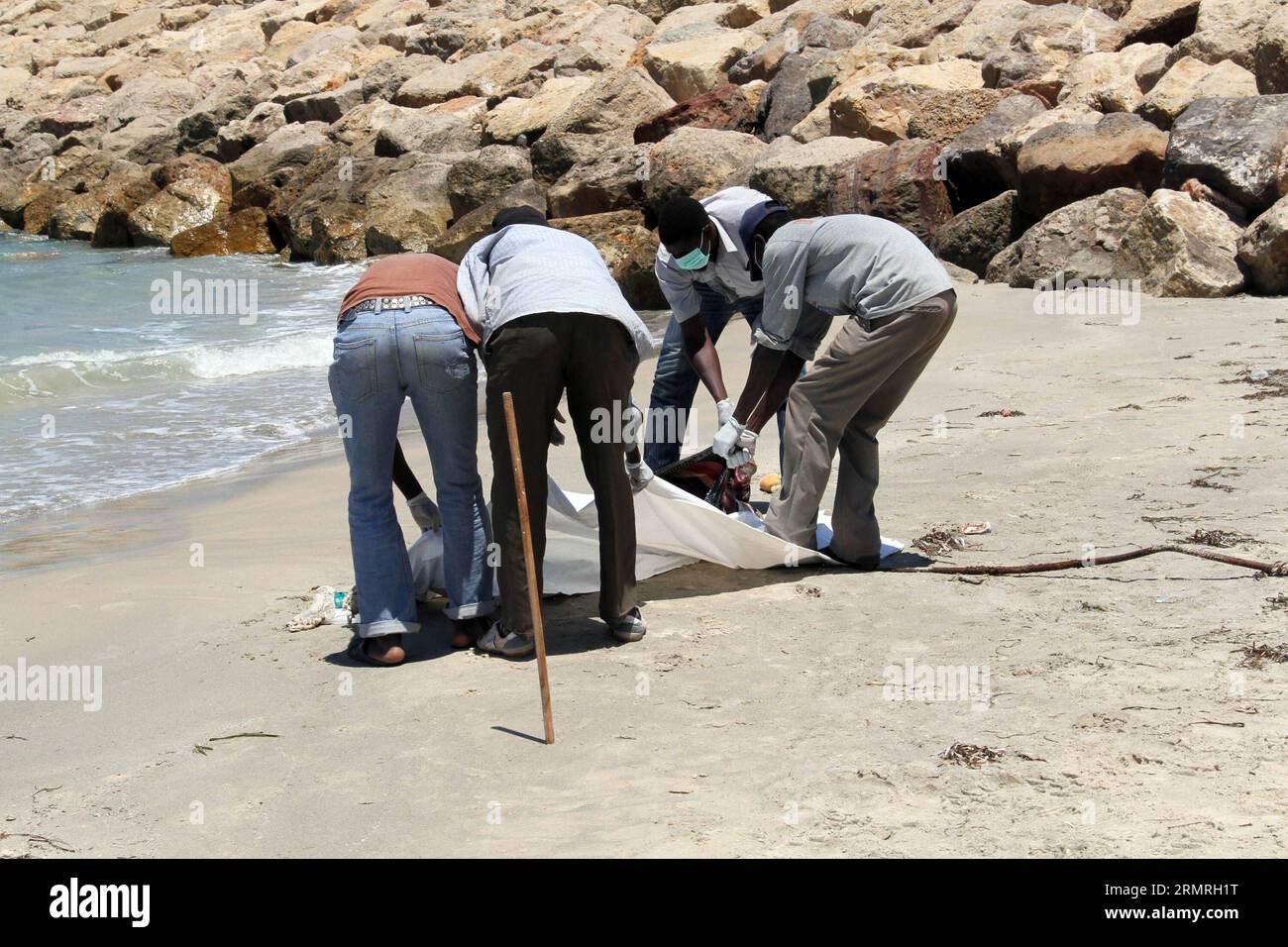 (140719) -- GARABULLI, 19 luglio 2014 (Xinhua) -- i soccorritori trasferiscono un corpo di un immigrato clandestino a Garabulli, Libia, il 19 luglio 2014. Circa 10 corpi sono stati trovati il sabato vicino alla città costiera di Garabulli, a circa 60 chilometri da Tripoli. La Libia è da tempo un punto di transito per i migranti che cercano di raggiungere Malta, l'Italia e altri luoghi in Europa a causa della sua vicinanza e del controllo delle frontiere relativamente lento. (Xinhua/Hamza Turkia) LIBIA-GARABULLI-IMMIGRATI ILLEGALI PUBLICATIONxNOTxINxCHN 19 luglio 2014 XINHUA Rescue Workers Transfer a Body of to illegal Immigration in Libia IL 19 luglio 20 Foto Stock