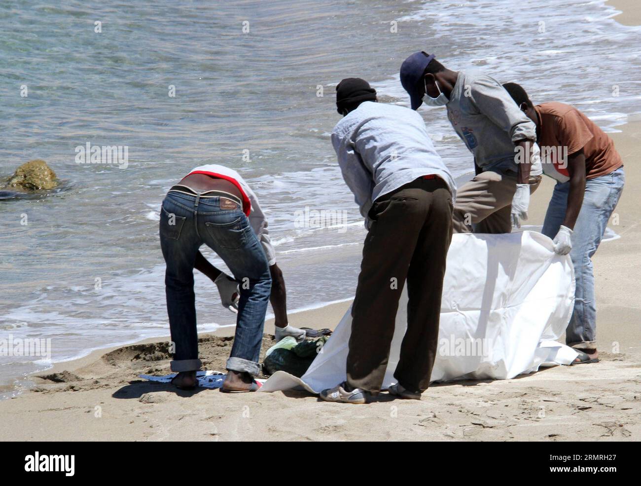(140719) -- GARABULLI, 19 luglio 2014 (Xinhua) -- i soccorritori trasferiscono un corpo di un immigrato clandestino a Garabulli, Libia, il 19 luglio 2014. Circa 10 corpi sono stati trovati il sabato vicino alla città costiera di Garabulli, a circa 60 chilometri da Tripoli. La Libia è da tempo un punto di transito per i migranti che cercano di raggiungere Malta, l'Italia e altri luoghi in Europa a causa della sua vicinanza e del controllo delle frontiere relativamente lento. (Xinhua/Hamza Turkia) LIBIA-GARABULLI-IMMIGRATI ILLEGALI PUBLICATIONxNOTxINxCHN 19 luglio 2014 XINHUA Rescue Workers Transfer a Body of to illegal Immigration in Libia IL 19 luglio 20 Foto Stock