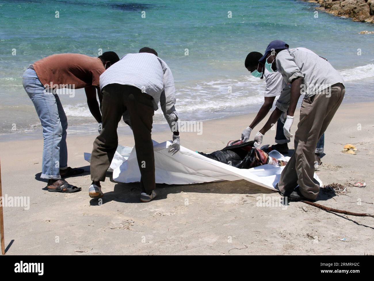(140719) -- GARABULLI, 19 luglio 2014 (Xinhua) -- i soccorritori trasferiscono un corpo di un immigrato clandestino a Garabulli, Libia, il 19 luglio 2014. Circa 10 corpi sono stati trovati il sabato vicino alla città costiera di Garabulli, a circa 60 chilometri da Tripoli. La Libia è da tempo un punto di transito per i migranti che cercano di raggiungere Malta, l'Italia e altri luoghi in Europa a causa della sua vicinanza e del controllo delle frontiere relativamente lento. (Xinhua/Hamza Turkia) LIBIA-GARABULLI-IMMIGRATI ILLEGALI PUBLICATIONxNOTxINxCHN 19 luglio 2014 XINHUA Rescue Workers Transfer a Body of to illegal Immigration in Libia IL 19 luglio 20 Foto Stock