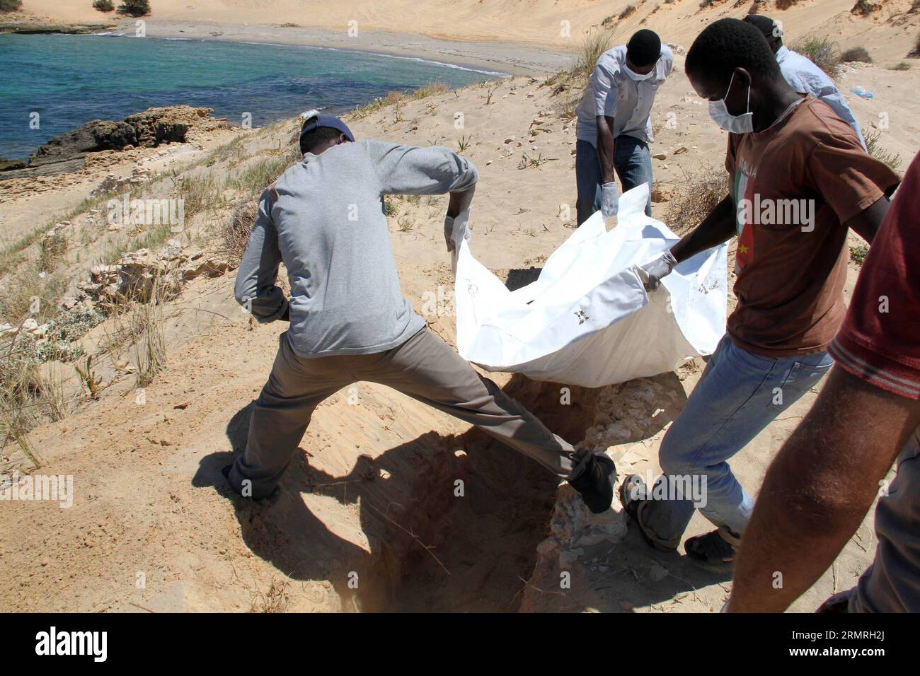 (140719) -- GARABULLI, 19 luglio 2014 (Xinhua) -- i soccorritori trasferiscono un corpo di un immigrato clandestino a Garabulli, Libia, il 19 luglio 2014. Circa 10 corpi sono stati trovati il sabato vicino alla città costiera di Garabulli, a circa 60 chilometri da Tripoli. La Libia è da tempo un punto di transito per i migranti che cercano di raggiungere Malta, l'Italia e altri luoghi in Europa a causa della sua vicinanza e del controllo delle frontiere relativamente lento. (Xinhua/Hamza Turkia) LIBIA-GARABULLI-IMMIGRATI ILLEGALI PUBLICATIONxNOTxINxCHN 19 luglio 2014 XINHUA Rescue Workers Transfer a Body of to illegal Immigration in Libia IL 19 luglio 20 Foto Stock