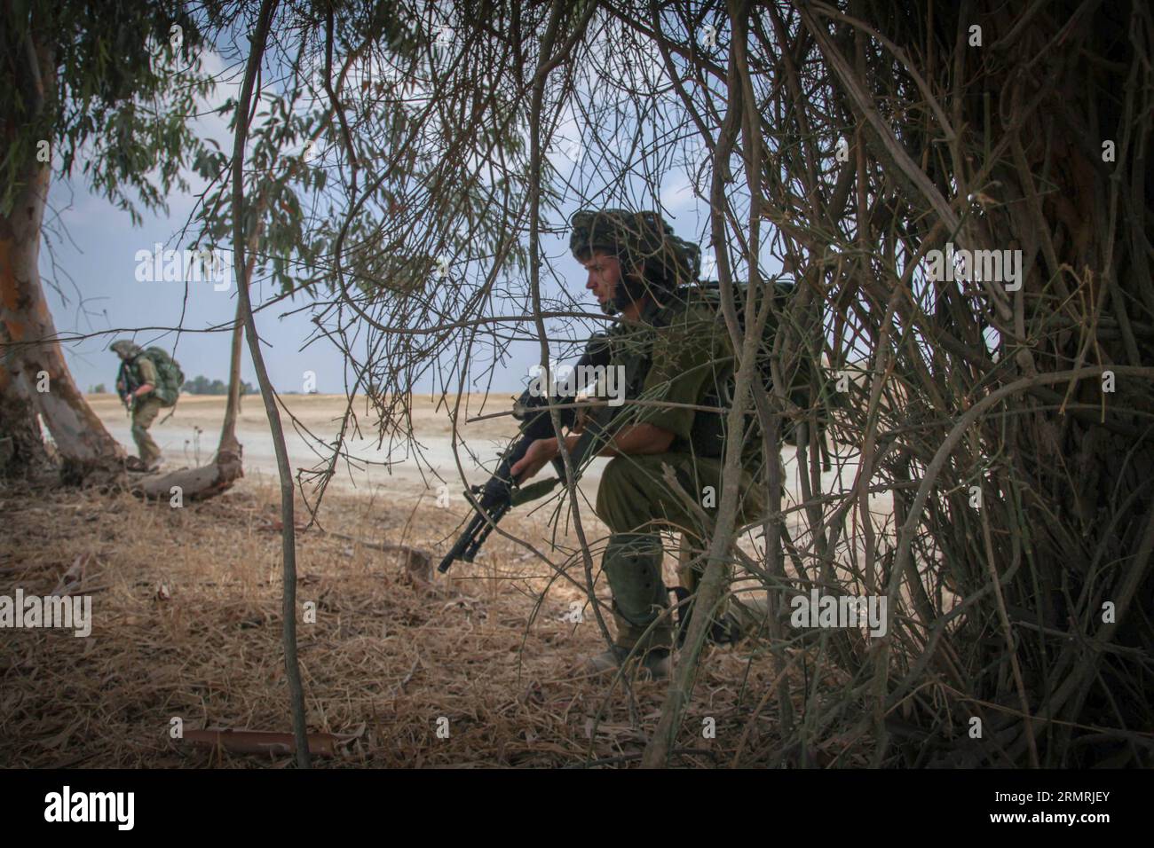 (140722) -- FRONTIERA DI GAZA, 22 luglio 2014 (Xinhua) -- i soldati israeliani sono posizionati vicino al confine tra Israele meridionale e Striscia di Gaza, il 15 ° giorno dell'operazione bordo protettivo, il 22 luglio 2014. Mentre il Segretario generale delle Nazioni Unite Ban Ki-Moon si trova in Israele per negoziare una pace tra lo Stato ebraico e il movimento islamista di Hamas, l’esercito israeliano ha affermato di non avere intenzione di cessare l’offensiva di Gaza prima di sradicare i tunnel terroristici che Hamas sta usando per intrufolarsi in Israele. (Xinhua/JINI/Albert Sadikov) ISRAEL-GAZA-BORDER-OPERATION-PROTECTIVE EDGE-THE 15TH DAY PUBLICATIONxNOTxINxCHN Gaza B Foto Stock