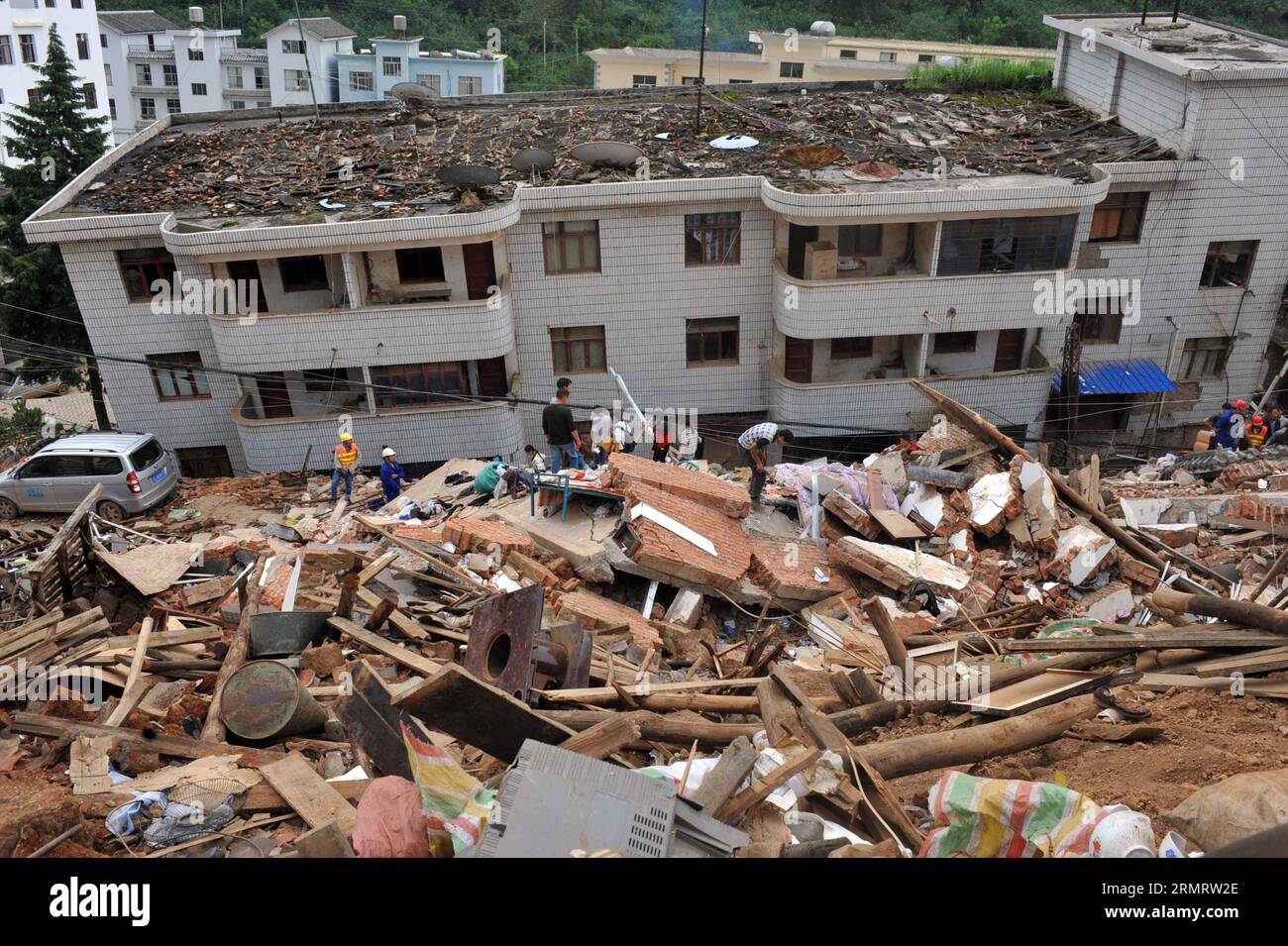 I soccorritori e i cittadini cercano i sopravvissuti tra le rovine dopo un terremoto di magnitudo 6,5 ha colpito Longtoushan Town sotto Ludian County di Zhaotong, nella provincia dello Yunnan della Cina sud-occidentale, 4 agosto 2014. Longtoushan Town è l'epicentro del terremoto, che ha colpito alle 16:30 domenica (ora di Pechino) con una profondità di 12 km Alle 14:00 di lunedì, il terremoto ha ucciso 398 persone e ne ha feriti 1.801, colpendo più di un milione di altre a Zhaotong e Qujing. ) (lmm) CHINA-YUNNAN-LUDIAN-EARTHQUAKE-EPICENTER-RESCUE (CN) ChenxHaining PUBLICATIONxNOTxINxCHN Rescue and Citizens Search for Survivors Among Ru Foto Stock