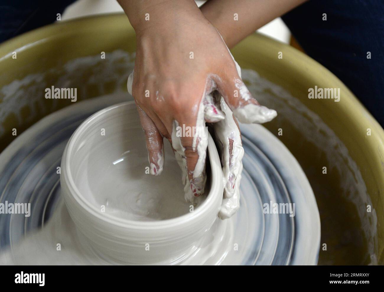 (140806) -- PECHINO, 6 agosto 2014 -- Zhang Lingyun lavora in uno studio nella sua casa a Jingdezhen, nella provincia del Jiangxi della Cina orientale, 18 luglio 2014. Zhang Lingyun ha 40 anni. Sono passati 20 anni da quando l'artista ceramico è venuto a Jingdezhen, capitale della porcellana cinese. La storia di Zhang con la ceramica ebbe un inizio casuale e romantico: Sapeva quasi nulla di ceramica prima di imbattersi nel nome Jingdezhen Ceramic Institute (JCI) quando si iscriveva al college. La ceramica sembrava interessante, quindi ho presentato la domanda per la JCI. Il capriccio d'impulso aveva fatto una grande differenza nella vita di Zhang. Il suo primo contatto wi Foto Stock