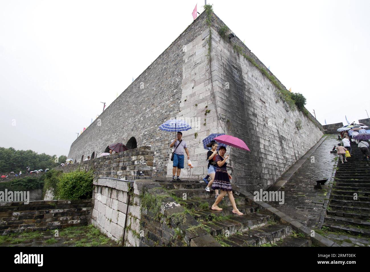 I turisti visitano la porta di Zhonghuamen, un barbacano che fa parte dell'antica cinta muraria della città di Nanchino, capitale della provincia di Jiangsu della Cina orientale, 8 agosto 2014. Le mura della città di Nanchino furono costruite tra il 1366 e il 1386, i primi anni della dinastia Ming (1368-1644). Un tempo capitale della dinastia, Nanchino era racchiusa da quattro strati di mura cittadine in mattoni di pietra. Dopo sei secoli di erosione naturale e distruzione umana di proposito, la lunghezza delle mura rimanenti ammonta a 25 chilometri, che ancora oggi fanno un record mondiale. () (LMM) CHINA-JIANGSU-NANJING-CITY WALL-TOURISM (CN) XINHUA PUBLIC Foto Stock