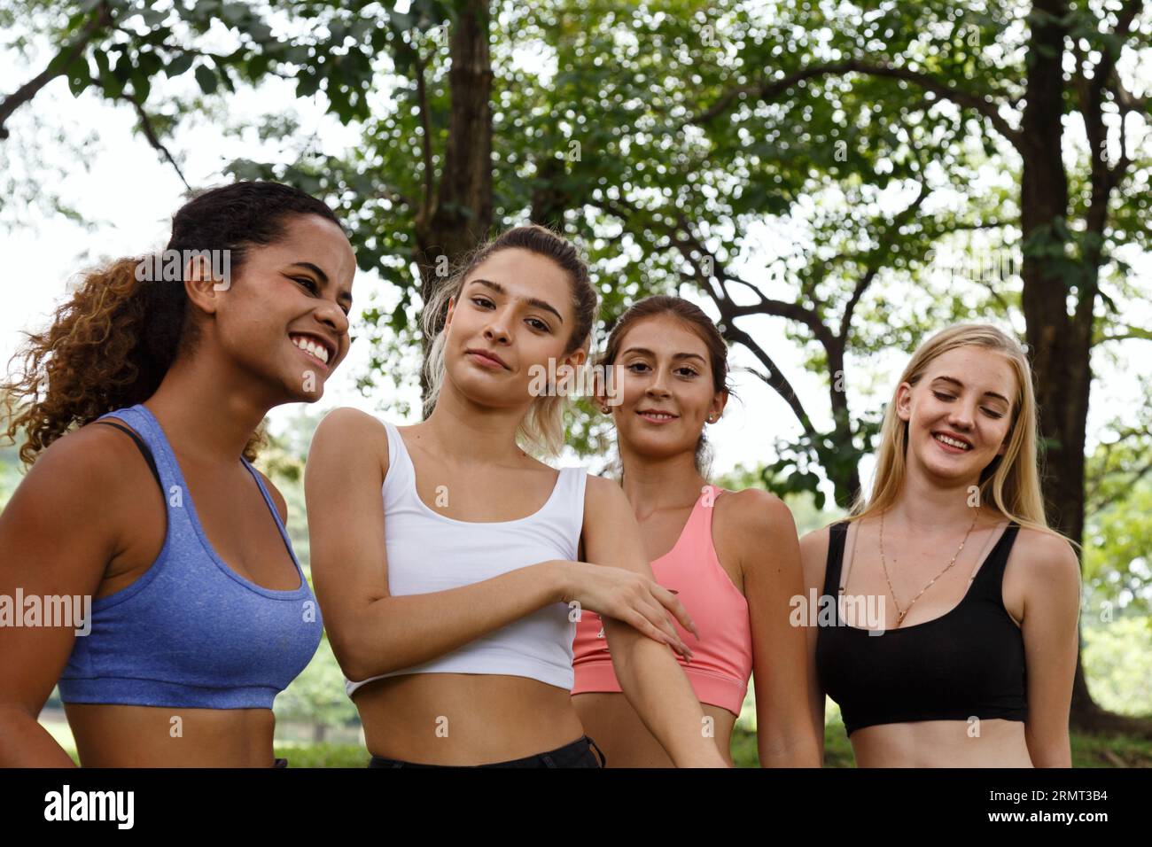 Felici amiche sorridenti. Donna che parla e si diverte nel parco dopo aver terminato la lezione di fitness yoga la mattina del fine settimana. Foto Stock