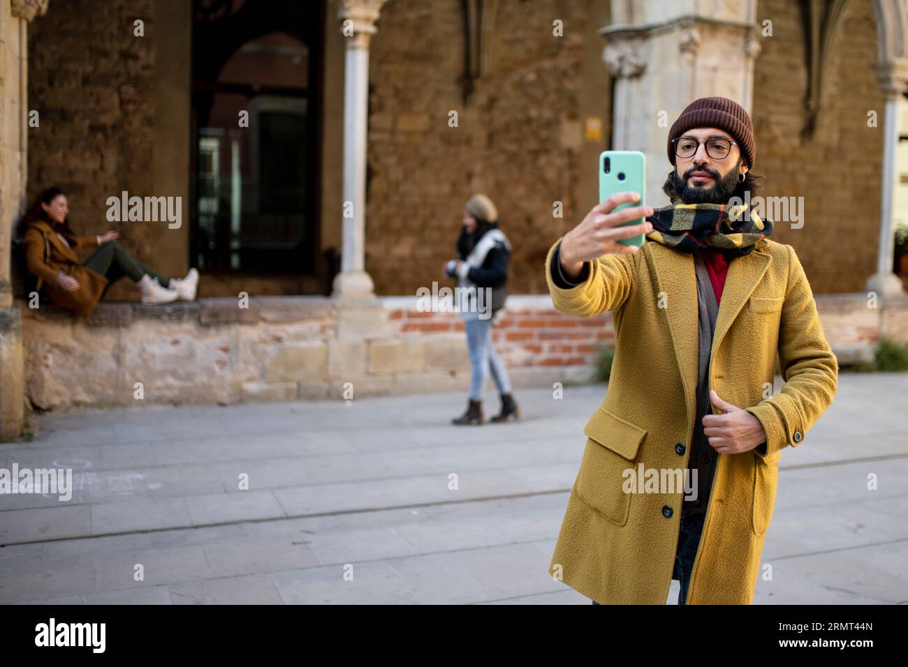 happy bearded young man taking a selfie in the old city - Young man using mobile phone at historic building. Vacations concept Foto Stock