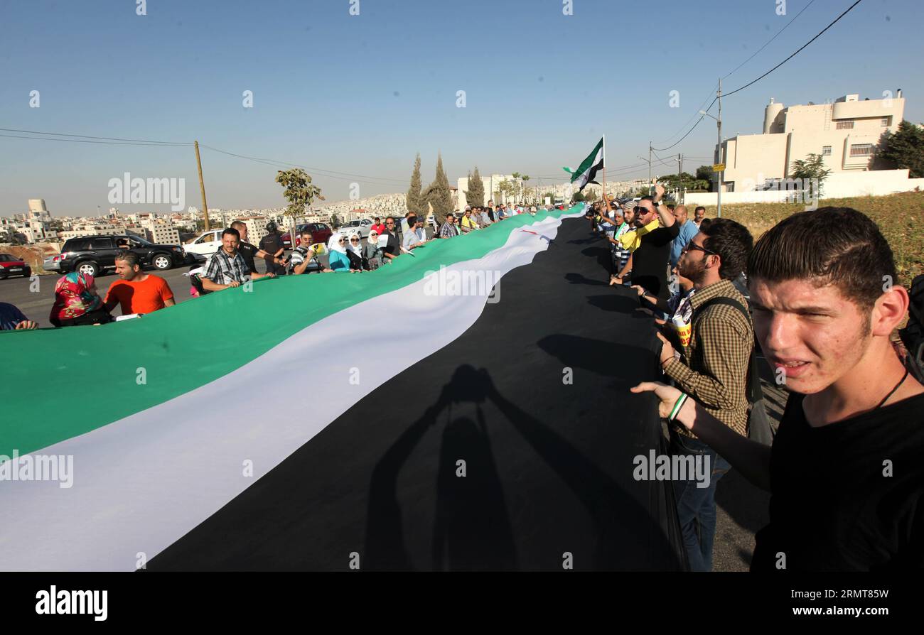 (140821) -- AMMAN, 21 agosto 2014-- siriani che vivono in Giordania portano striscioni e slogan urlanti contro il presidente siriano Bashar al-Assad davanti all'ambasciata siriana ad Amman, Giordania, 21 agosto 2014. Centinaia di siriani che vivono in Giordania si sono riuniti per celebrare l'anniversario degli attacchi chimici ad al-Ghouta il 21 agosto 2013. ) GIORDANIA-AMMAN-DIMOSTRAZIONE MohammadxAbuxGhosh PUBLICATIONxNOTxINxCHN Amman 21 agosto 2014 siriani che vivono in Giordania Banner e slogan Shout contro il presidente siriano Bashar al Assad di fronte all'ambasciata siriana ad Amman Giordania 21 agosto 2014 centinaia di celebrità siriane Livi Foto Stock