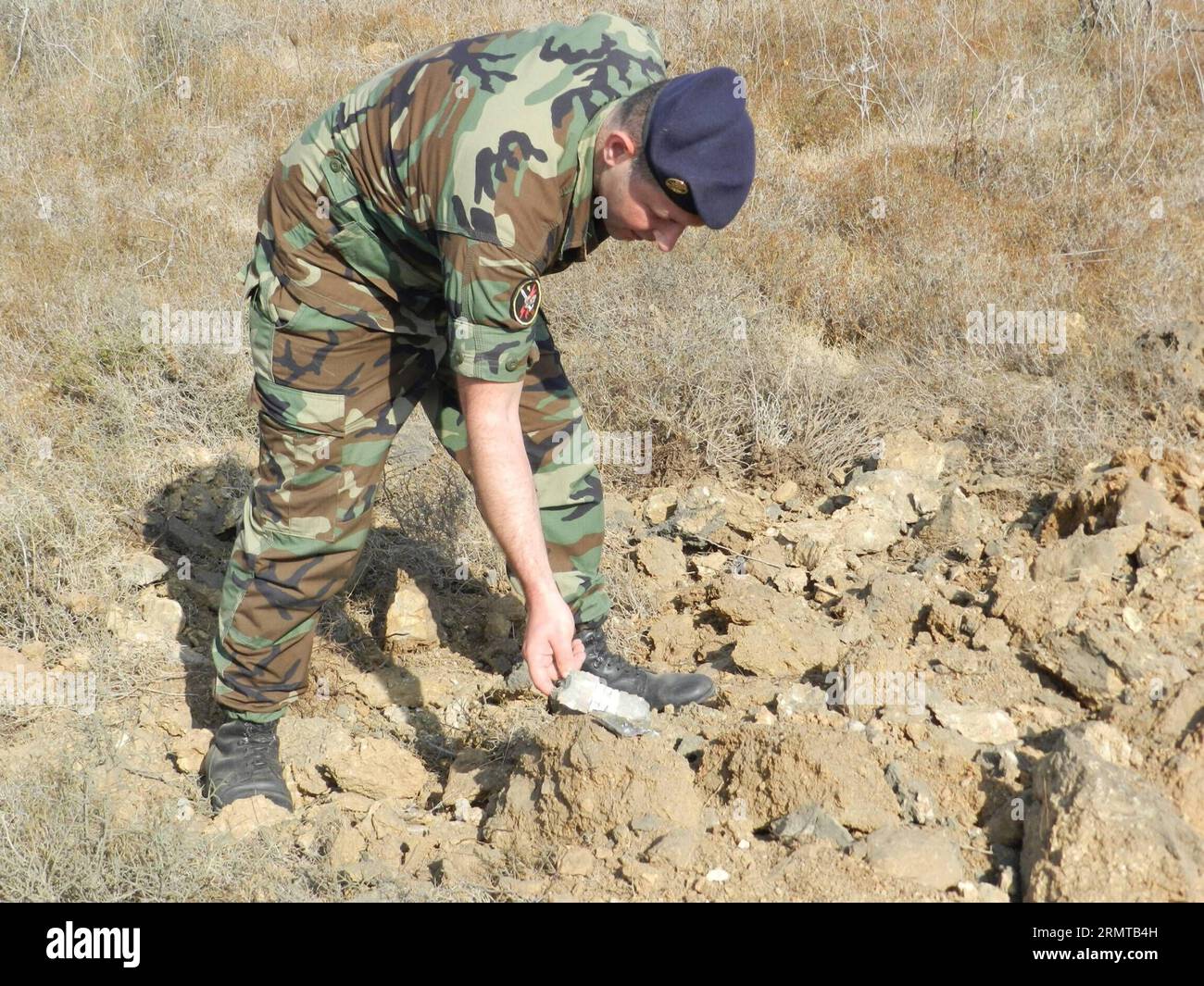 (140826) -- BEIRUT, 26 agosto 2014 -- Un soldato libanese controlla un frammento di conchiglie dopo uno sciopero israeliano, nella valle del fiume Litani, a 10 chilometri dai confini con Israele, 26 agosto 2014. Gli assalitori sconosciuti hanno sparato lunedì sera almeno un razzo dal sud del Libano verso i territori occupati nel nord di Israele. Per rappresaglia, l'artiglieria israeliana sparò diversi proiettili sull'area dove i razzi avevano origine. LIBANO-ISRAELE-RAZZO-ATTACK Taher PUBLICATIONxNOTxINxCHN Beirut agosto 26 2014 un soldato libanese dell'esercito controlla un frammento di Shell dopo lo sciopero israeliano alla Litani R. Foto Stock